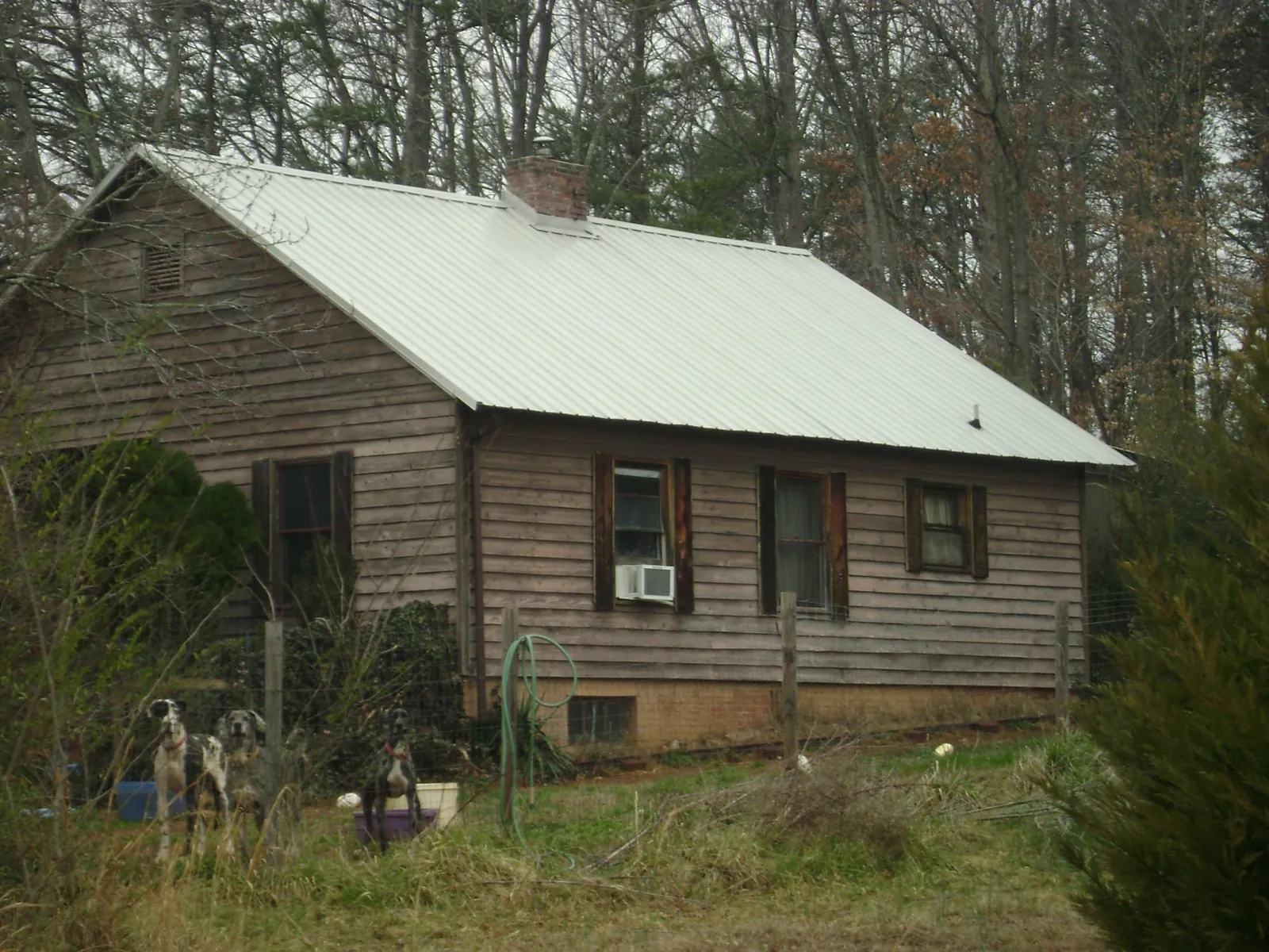 White metal roof on an old wood sided farmhouse, from a Metal Roof Installation job in Columbus Junction